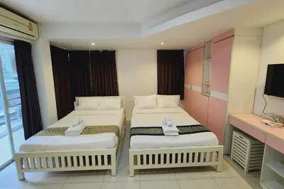 two beds in a small room with a tv at Zenith Life Hotel in Ban Bang Khen (1)