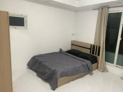 a bedroom with a bed and two windows at Am Am Place C แอม แอม เพลส C Near Rajmangkala Stadiume in Sathani Khlong Tan