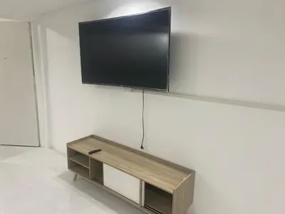 a flat screen tv hanging on a wall at Am Am Place C แอม แอม เพลส C Near Rajmangkala Stadiume in Sathani Khlong Tan