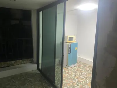 a room with a microwave on top of a refrigerator at Am Am Place C แอม แอม เพลส C Near Rajmangkala Stadiume in Sathani Khlong Tan