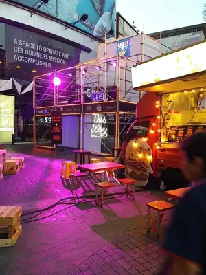 a food truck is parked next to a table and benches at Sky Residence in Ekkamai in Bangkok