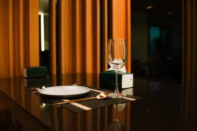a table with a plate and a wine glass on it at Zenith Place Huge 2BR Low-rise condo in Bangkok