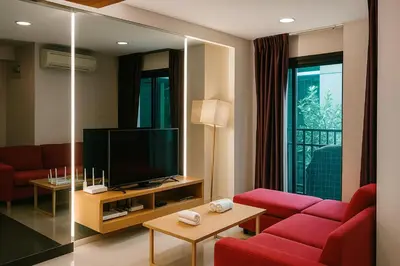 a living room with a red couch and a television at Zenith Place Huge 2BR Low-rise condo in Bangkok