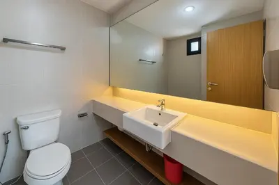 a bathroom with a sink and a toilet and a mirror at Zenith Place Huge 2BR Low-rise condo in Bangkok