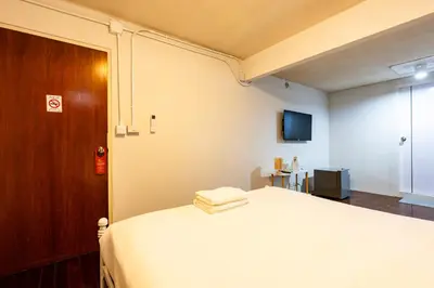a bedroom with a white bed and a tv at xx Stay On Sukhumvit Soi 11 BTS Nana in Bangkok