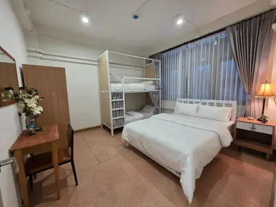 a bedroom with a large white bed and a desk at Vintana Siam Bangkok Hotel in Bangkok