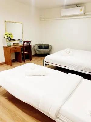 two beds in a room with a desk and a chair at Vintana Siam Bangkok Hotel in Bangkok