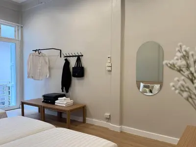 a bedroom with two beds and a mirror and a table at Vélin - Banthat Thong in Bangkok