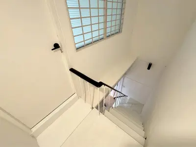 a white staircase with a window in a building at Vélin - Banthat Thong in Bangkok
