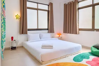 a bedroom with a large white bed and windows at Cozy&Modern 6-BR Home, 14pax - Central, 5mins BTS in Bangkok
