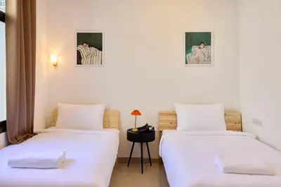 two beds in a room with white walls at Cozy&Modern 6-BR Home, 14pax - Central, 5mins BTS in Bangkok