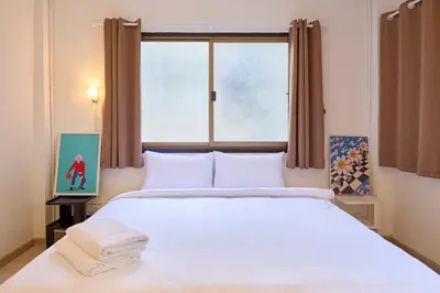 a bedroom with a large white bed with a window at Cozy&Modern 6-BR Home, 14pax - Central, 5mins BTS in Bangkok