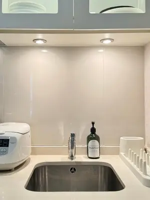 a kitchen sink with a bottle of wine on it at Luxury Prime Thong Lor - Fast WiFi, Gym&Pool in Bangkok