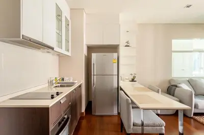 a kitchen with a sink and a refrigerator at Luxury Prime Thong Lor - Fast WiFi, Gym&Pool in Bangkok
