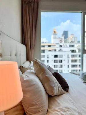 a bed with pillows and a window with a view at Luxury Prime Thong Lor - Fast WiFi, Gym&Pool in Bangkok