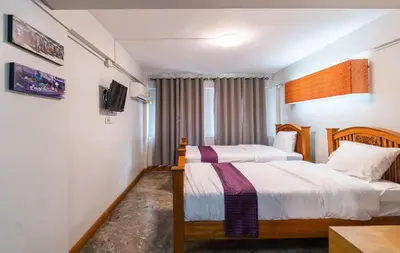 a hotel room with two beds and a tv at XX GO INN Khaosan - โกอินน์ ถนนข้าวสาร in Bangkok