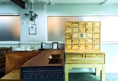 a room with a desk and a wooden cabinet at XX GO INN Khaosan - โกอินน์ ถนนข้าวสาร in Bangkok