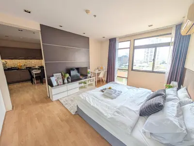 a bedroom with a large white bed and a kitchen at Executive Suite 1BR and Sofa Bed 150m to Nana BTS in Bangkok