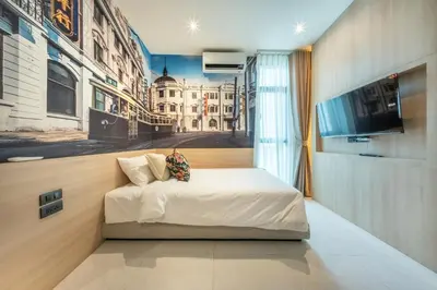 a bedroom with a bed with a painting on the wall at U TOR Yaowarat - Bangkok Chinatown in Bangkok