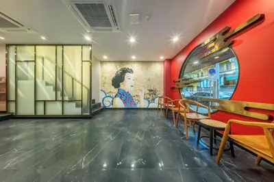 a restaurant with red walls and tables and chairs at U TOR Yaowarat - Bangkok Chinatown in Bangkok