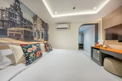 a bedroom with a large white bed and a tv at U TOR Yaowarat - Bangkok Chinatown in Bangkok