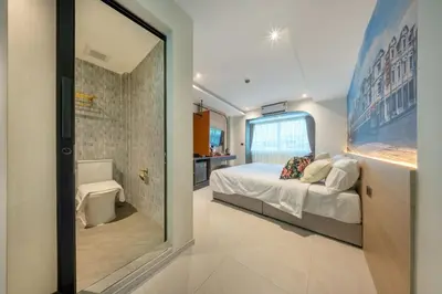 a small bedroom with a bed and a bathroom at U TOR Yaowarat - Bangkok Chinatown in Bangkok