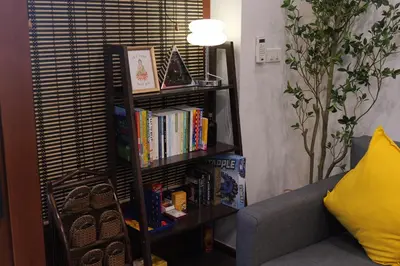 a book shelf filled with books next to a couch at Entire Home 2BR 2BA Chinatown near Yaowarat - Songwat in Bangkok