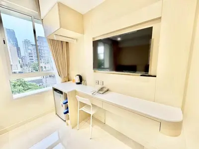 a white bathroom with a sink and a window at ABCQQ Hotel Bangkok in Bangkok