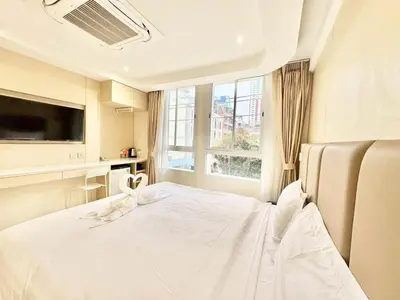 a bedroom with a bed with white sheets and a window at ABCQQ Hotel Bangkok in Bangkok
