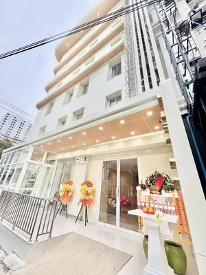 a white building with a table in front of it at ABCQQ Hotel Bangkok in Bangkok