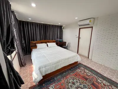 a bedroom with a large bed and a rug at Baan Saen Saran guest house in Bangkok