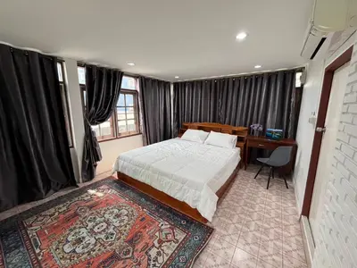 a bedroom with a bed and a desk in it at Baan Saen Saran guest house in Bangkok