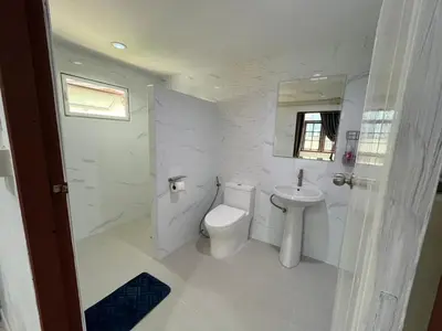 a white bathroom with a toilet and a sink at Baan Saen Saran guest house in Bangkok