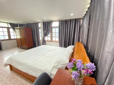 a bedroom with a bed and a table with flowers on it at Baan Saen Saran guest house in Bangkok