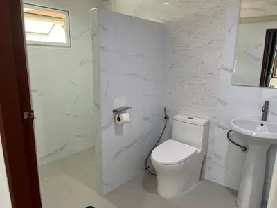 a white bathroom with a toilet and a sink at Baan Saen Saran guest house in Bangkok