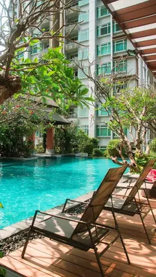 a pair of chairs sitting next to a swimming pool at The Condo C - Luxury Condo with Onsen in Bangkok