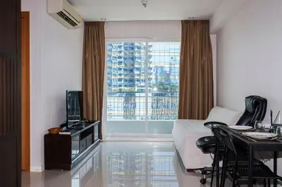a room with a bed and a table and a window at The Condo C - Luxury Condo with Onsen in Bangkok