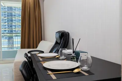 a black table with a plate and glasses on it at The Condo C - Luxury Condo with Onsen in Bangkok