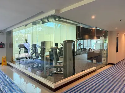 a gym with glass walls and exercise equipment at The Condo C - Luxury Condo with Onsen in Bangkok