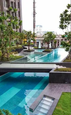 a large swimming pool with blue water in a building at The Elite Club - ThongLor Bangkok in Bangkok