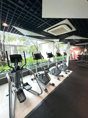 a gym with a row of treadms and cardio machines at The Elite Club - ThongLor Bangkok in Bangkok