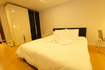 a white teddy bear sitting on top of a bed at The Silent Sanctum in Bangkok