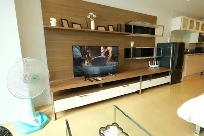 a living room with a large entertainment center with a tv at The Silent Sanctum in Bangkok