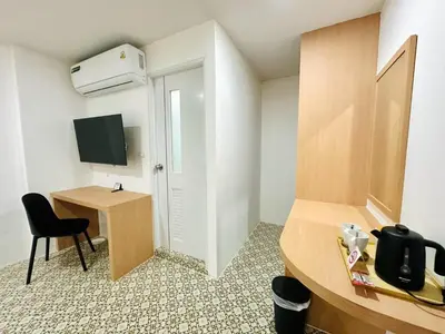 a small room with a desk and a television at The Cozy 77 in Bangkok