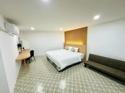 a hotel room with a bed and a desk at The Cozy 77 in Bangkok