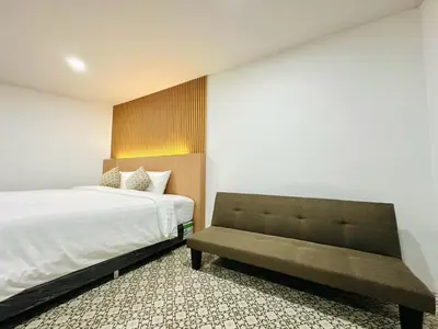 a bedroom with a bed and a bench in it at The Cozy 77 in Bangkok