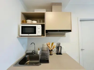 a kitchen with a sink and a microwave at Cosy apartment in Bangkok