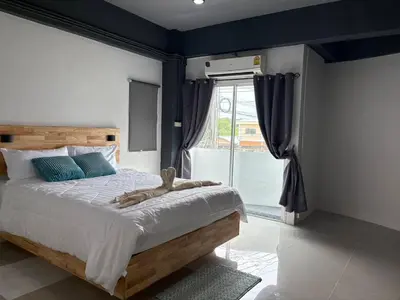 a bedroom with a large bed with a large window at Irich Bang Hua Suae 6kms from BTS Pu-Chao in Ban Bang Chak