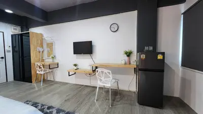 a small room with a desk and a refrigerator at Irich Bang Hua Suae 6kms from BTS Pu-Chao in Ban Bang Chak