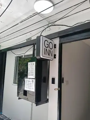 a go inn sign hanging on a wall next to a door at XX GO INN Siriraj BKK - โกอินน์ ศิริราช in Bangkok Noi